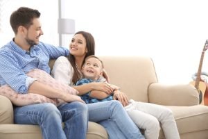 The family is sitting on the couch.