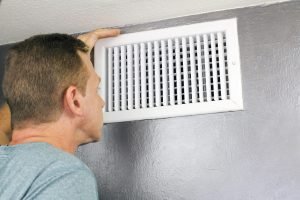 A person is inspecting a radiator.