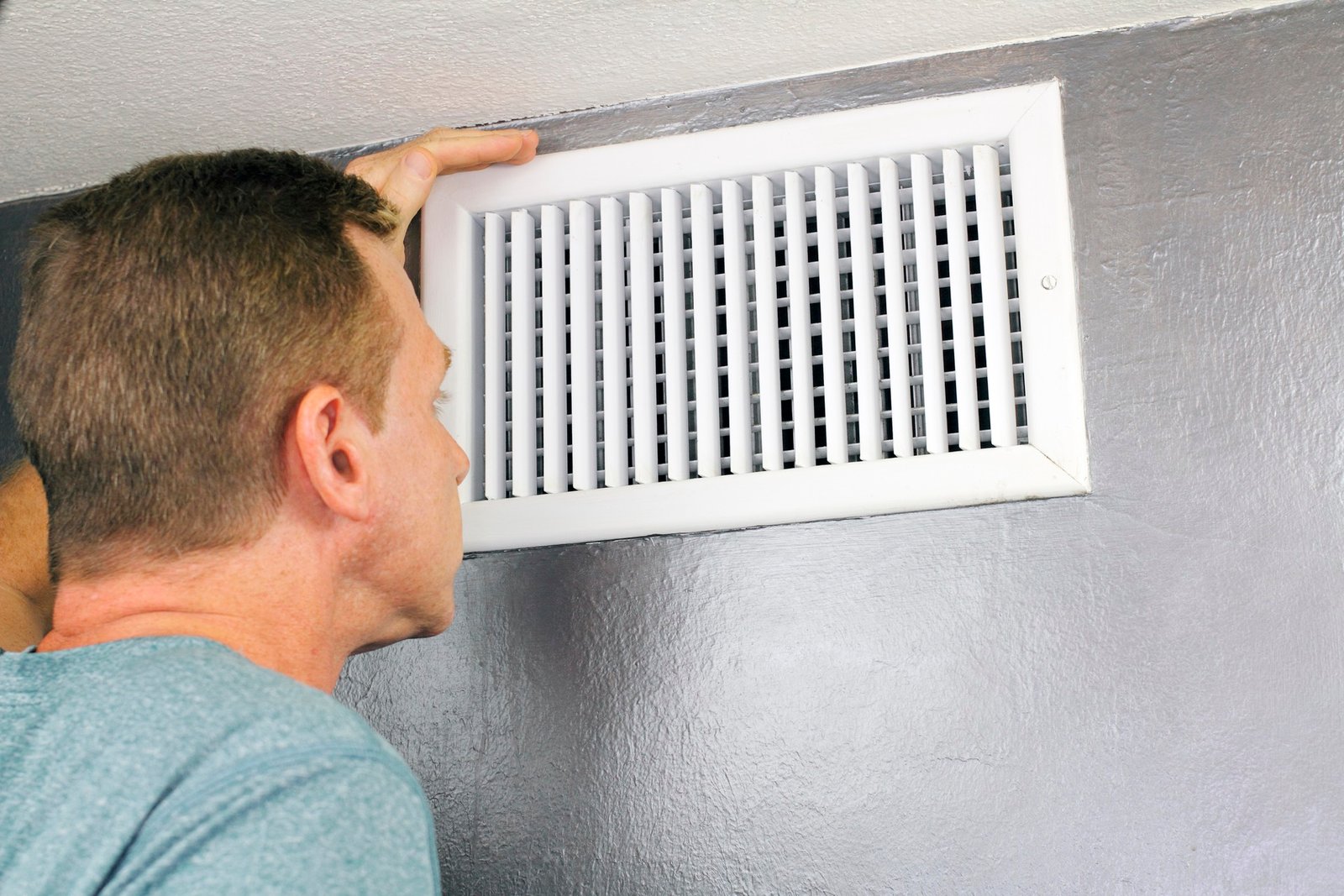 A person is inspecting a radiator.